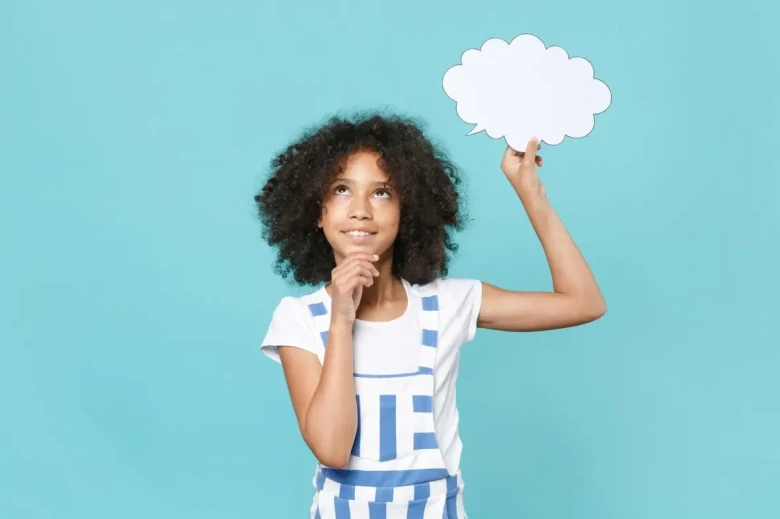 girl looking up at the sky holding a cut out speech bubble above her head