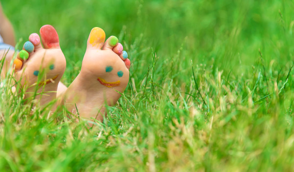 child with painted feet on grass