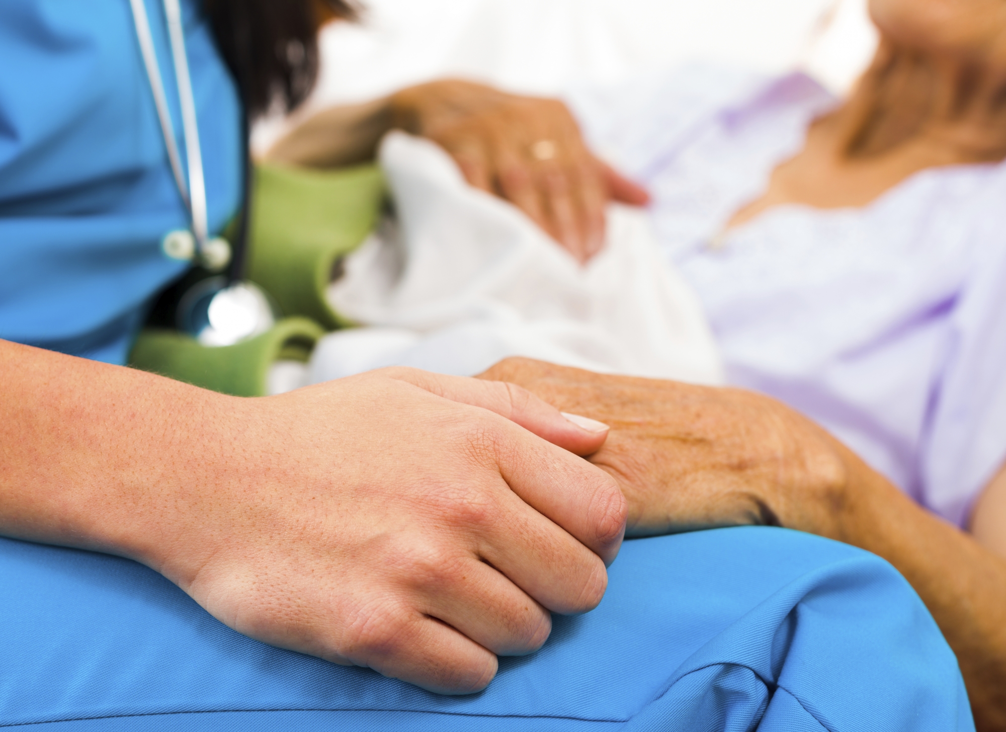 Image or nurse and patient holding hands