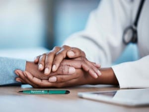 a picture of a healthcare worker holding hands with a patient.