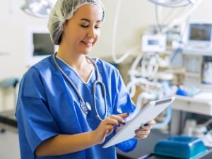 a picture of a female healthcare worker holding an electronic device.