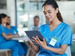 A picture showing a female healthcare on a System C branded electronic device.