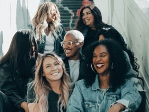 A picture of multiple woman sat smiling at each other.