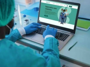 A picture of a NHS healthcare professional on the System C website on a laptop.