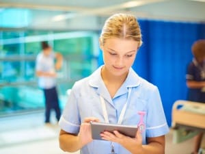A Picture of w female healthcare worker using a digital device.