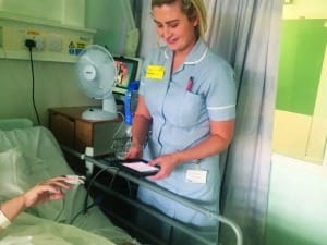 A picture of a female healthcare worker using an EPR with a patient.