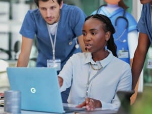 A picture of healthcare professionals looking at a laptop and using CareFlow EPR.