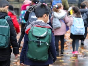 An image of students walking to school in the rain.