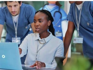 A picture of healthcare professionals using an electronic patient record on a System C laptop.