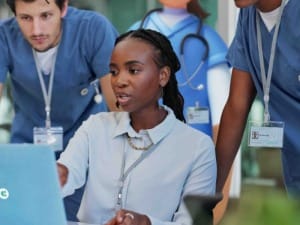 A picture of healthcare professionals using an electronic patient record on a System C laptop.