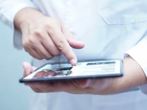 An image of a clinician using a piece of technology to help them.