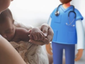 An image of a newborn baby being held and a System C clinician.
