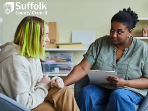 A picture of a social worker having a conversation with a young adult.